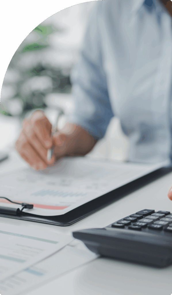 Close-up of professional reviewing financial charts with a calculator, showing accuracy and detail in bookkeeping services in Dubai.