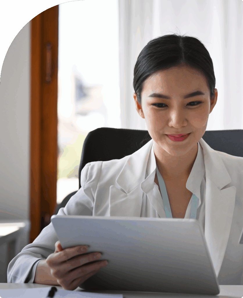 Smiling business professional in white reviewing financial data on a tablet, representing efficient bookkeeping services in Dubai.