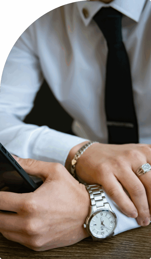 Close-up of businessman in a white shirt and tie using smartphone, symbolising efficient and professional business setup in Dubai.