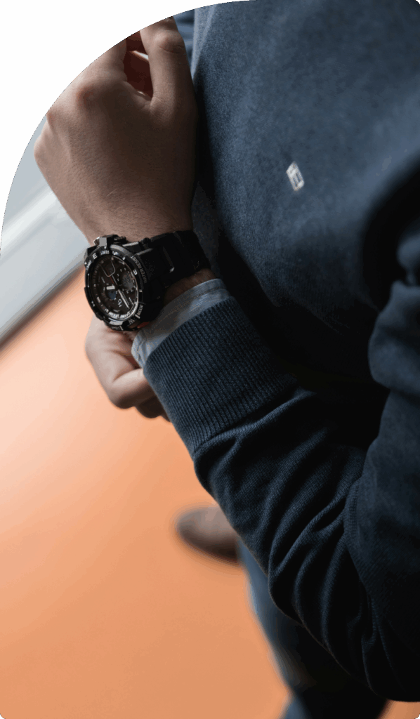 Close-up of man in dark jumper checking time on a luxury watch, representing long-term security with a Cyprus international trust.