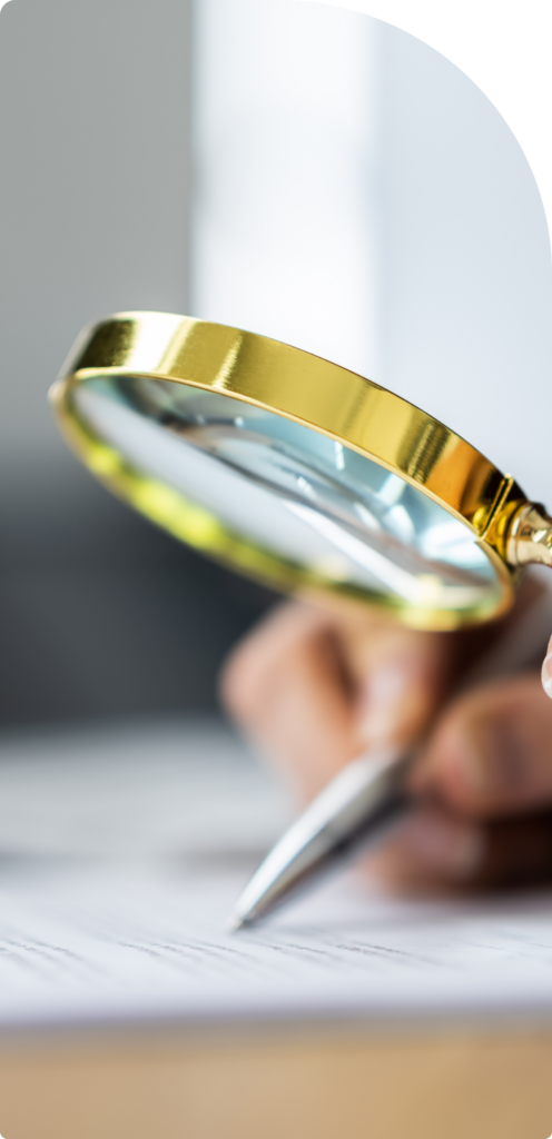 A professional carefully reviewing legal documents with a magnifying glass, ensuring accuracy and compliance in business agreements.