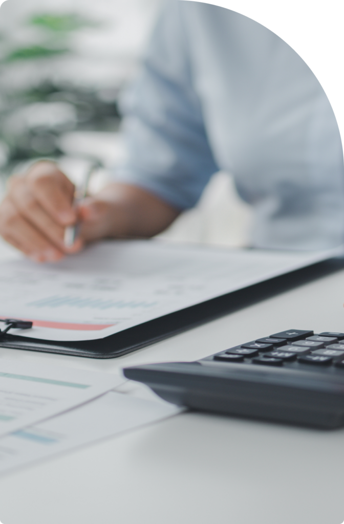 A professional calculating business finances and reviewing financial documents, representing tax planning, accounting, and corporate banking solutions in Dubai.