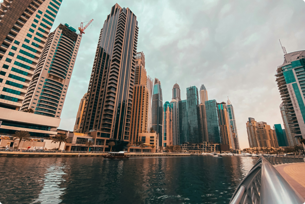 A stunning view of Dubai Marina’s high-rise skyline reflecting on the waterfront, symbolizing luxury living, business opportunities, and foreign investment in the UAE.