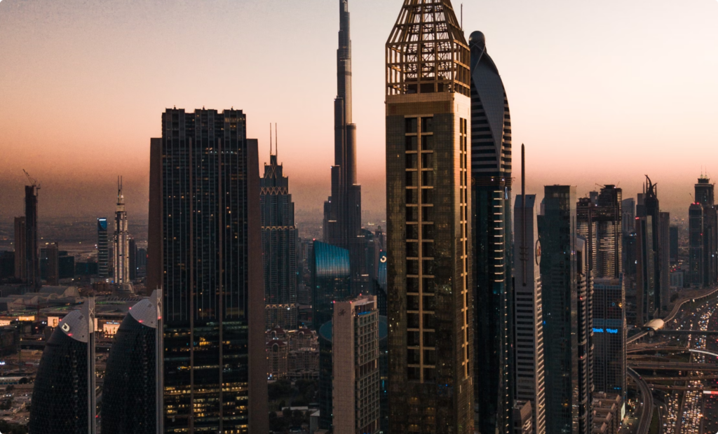 An aerial view of Dubai’s skyline at sunset, featuring Burj Khalifa and high-rise towers, representing luxury, global business opportunities, and investment potential in the UAE.