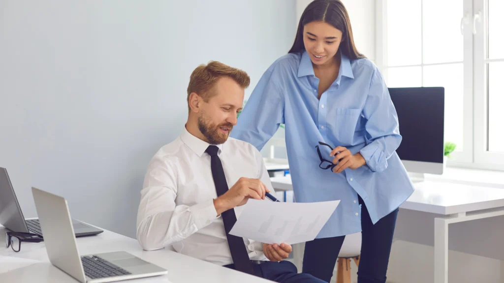 a woman helping a man go over information on a document