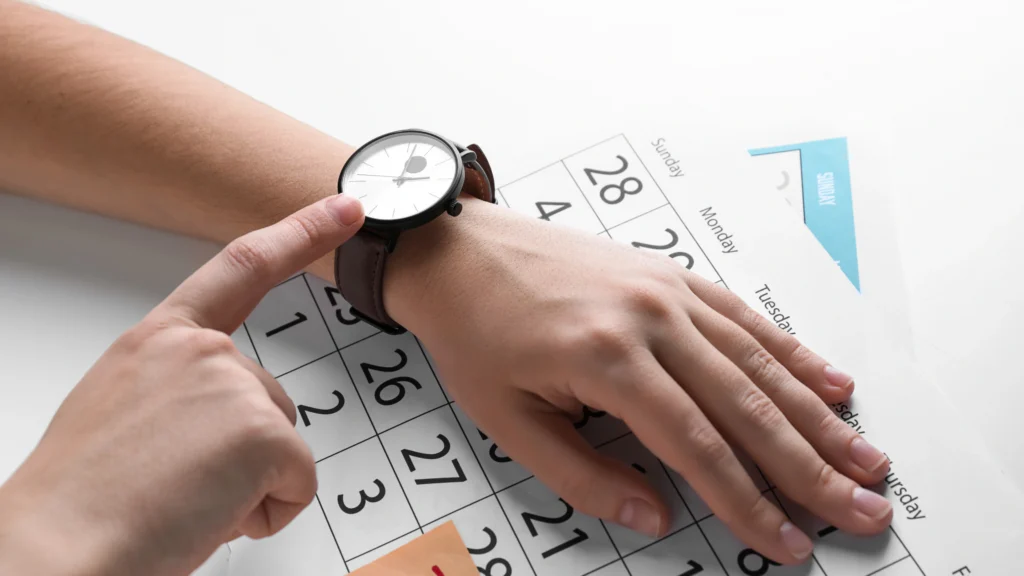 person looking at their watch and calendar