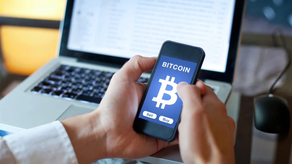 a man interacting with a virtual currency application on his phone