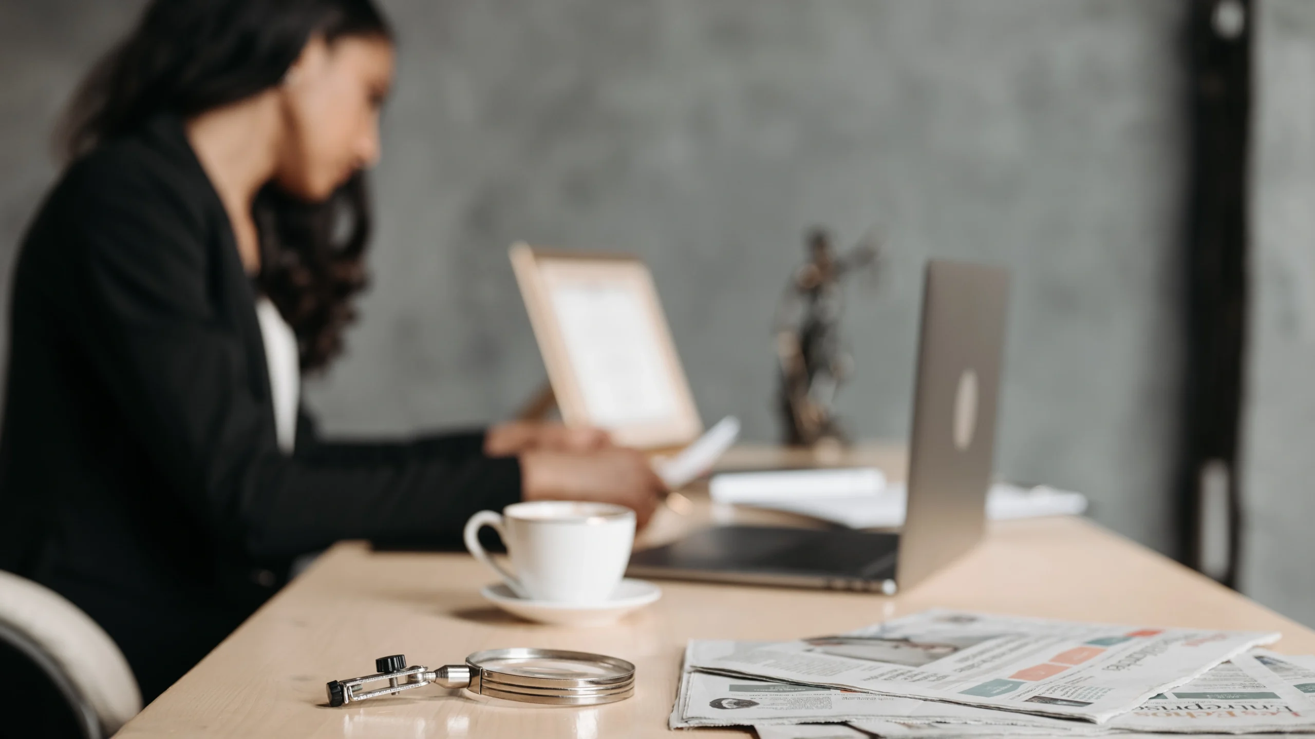 a woman out of camera focus working on her laptop