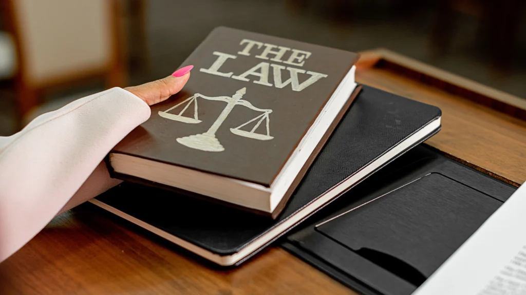 person grabbing a book that goes over the law