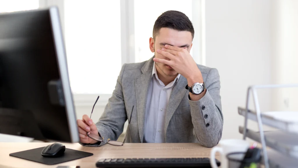 person having a headache because of work in their office