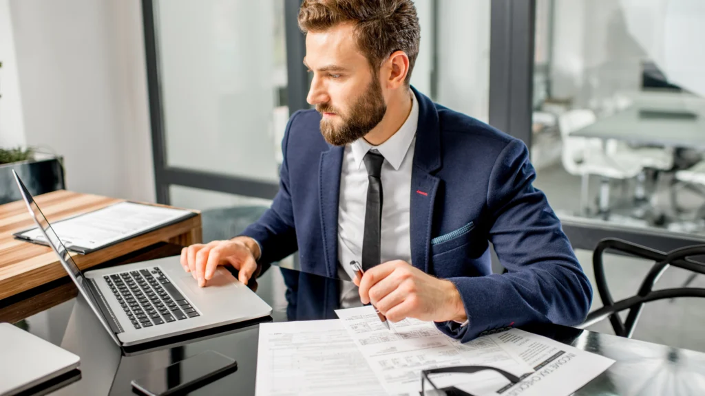 an agent working on his laptop while sitting in his office