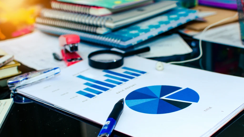Graphs, charts, notebooks, and other important documents on someone's work desk