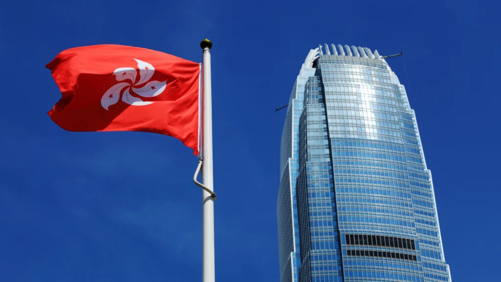 a huge business building in the background and a hong kong flag in the front