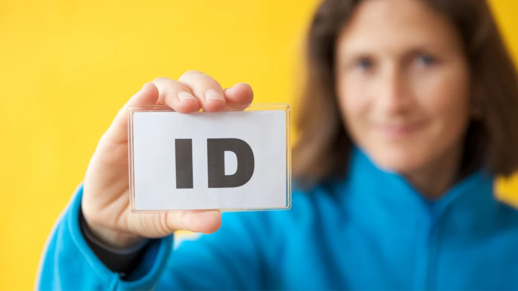 man holding up a small card that says ID on it