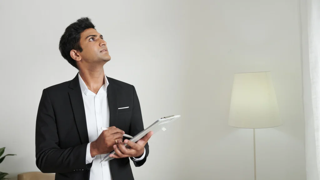 an agent with a clipboard in hand looking around his office