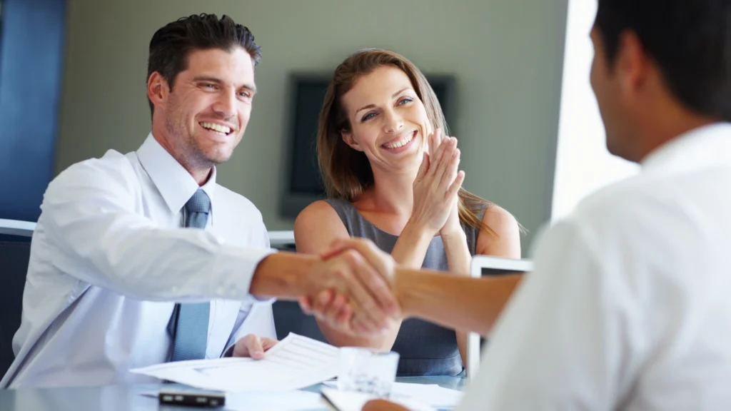 three people shaking hands and celebrating after onboarding an investor