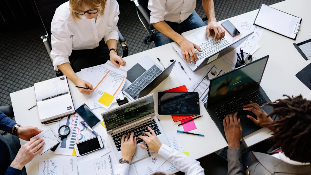 people working together on a desk in their office