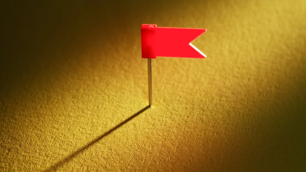 a red flag planted on a board