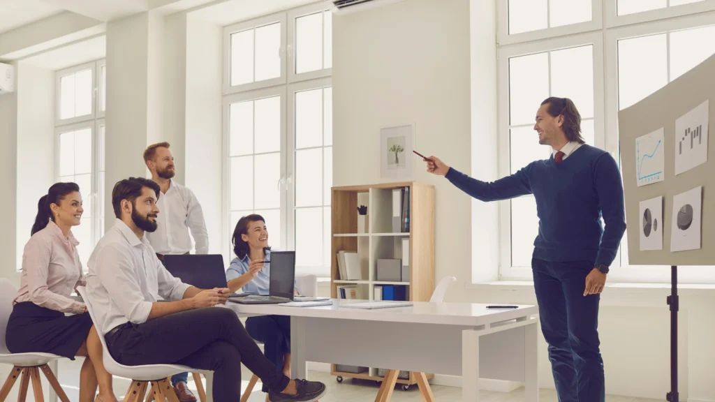Employees listening to their manager present information in the office