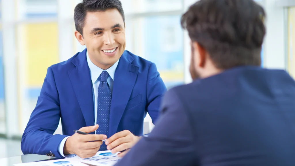 a man interviewing another man for the position of an agent