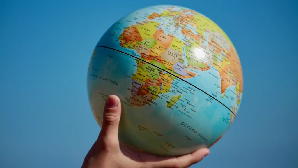 person holding up a globe of the Earth