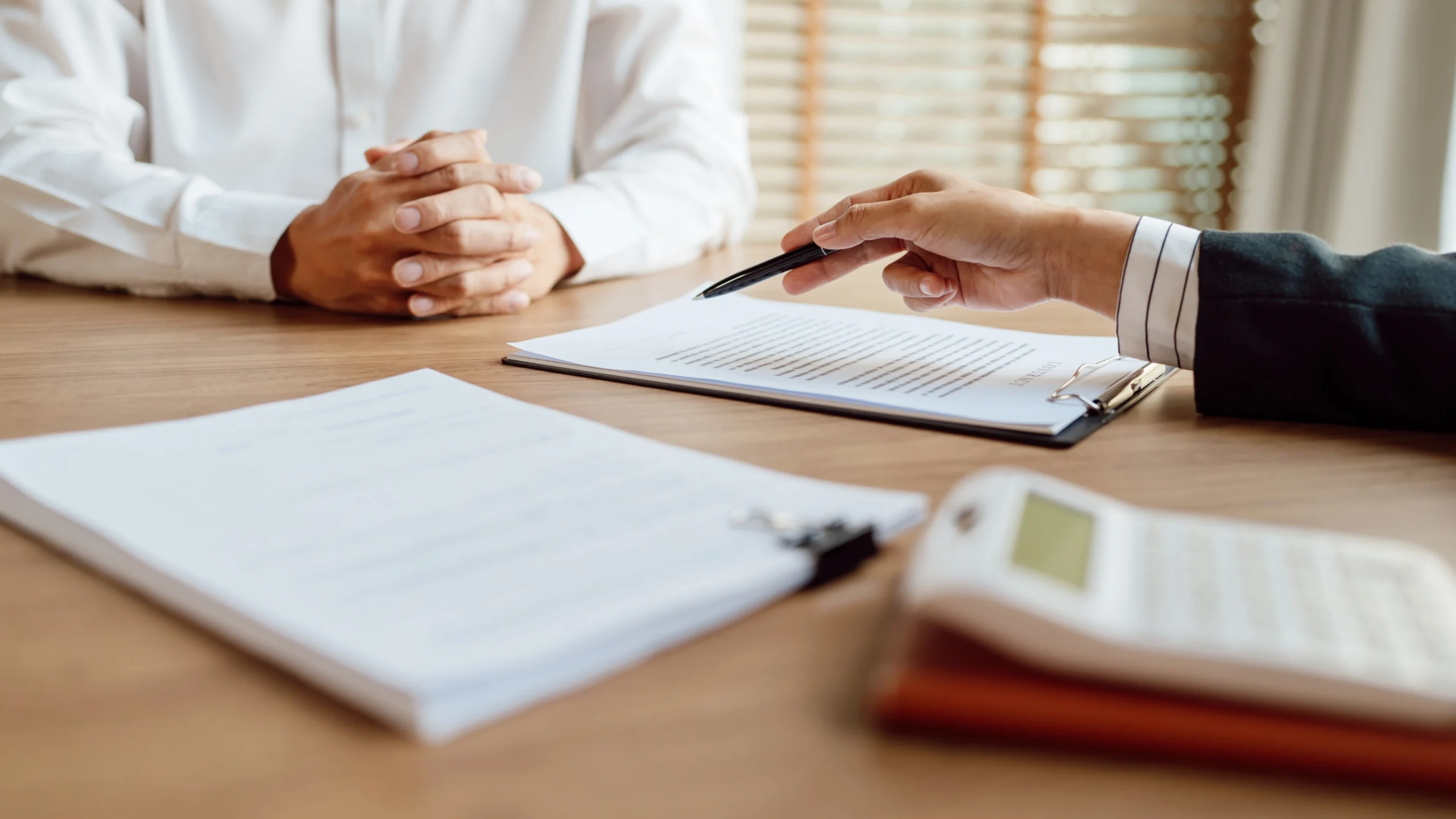 two people in the middle of a meeting with one showing the other some documents