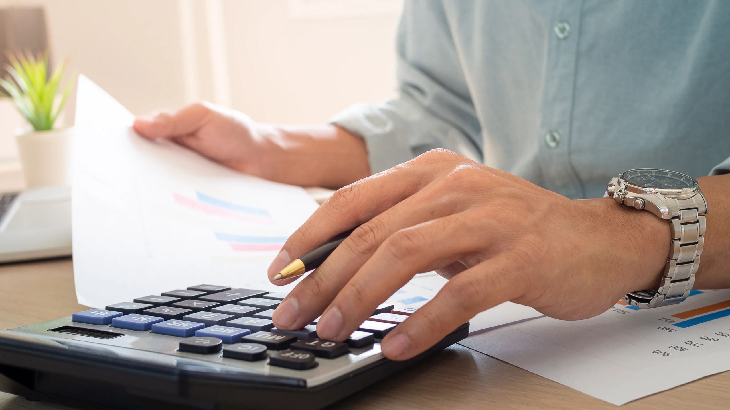 person looking at documents and calculating figures