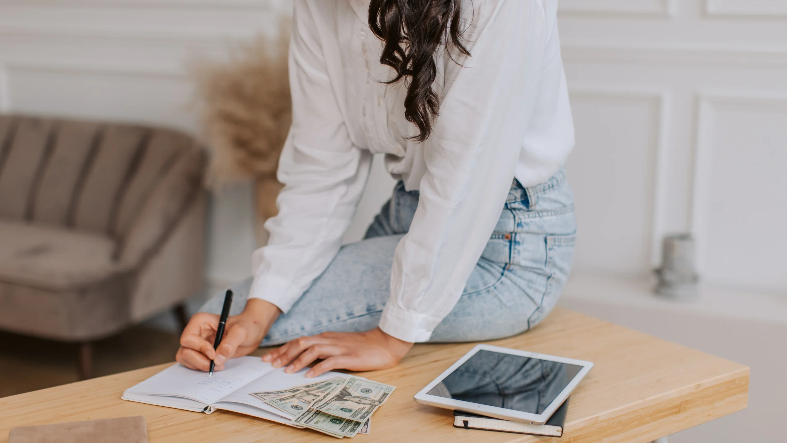 a woman calculating her budget with money on the table