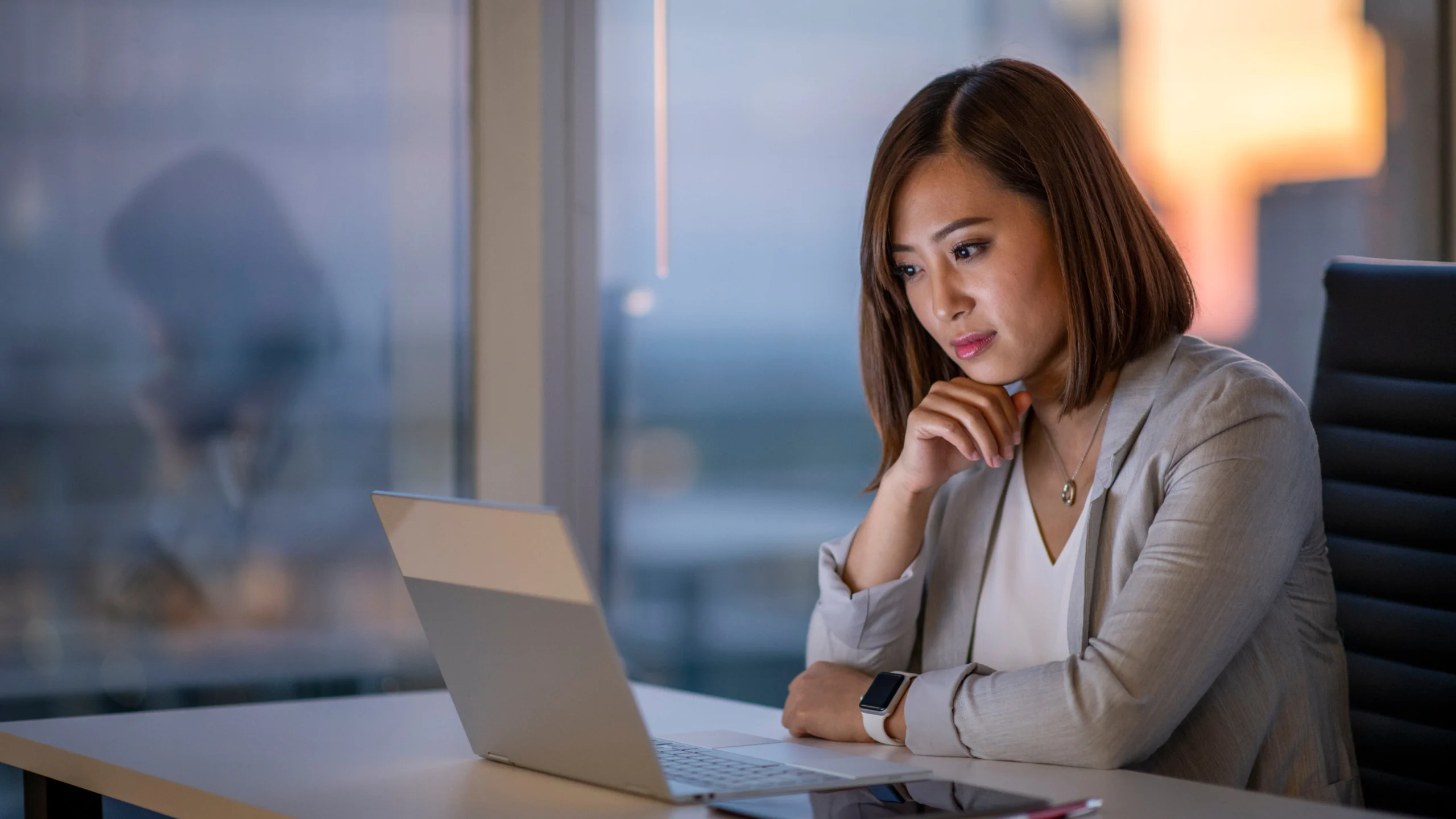 a woman staring at her laptop while working in her office