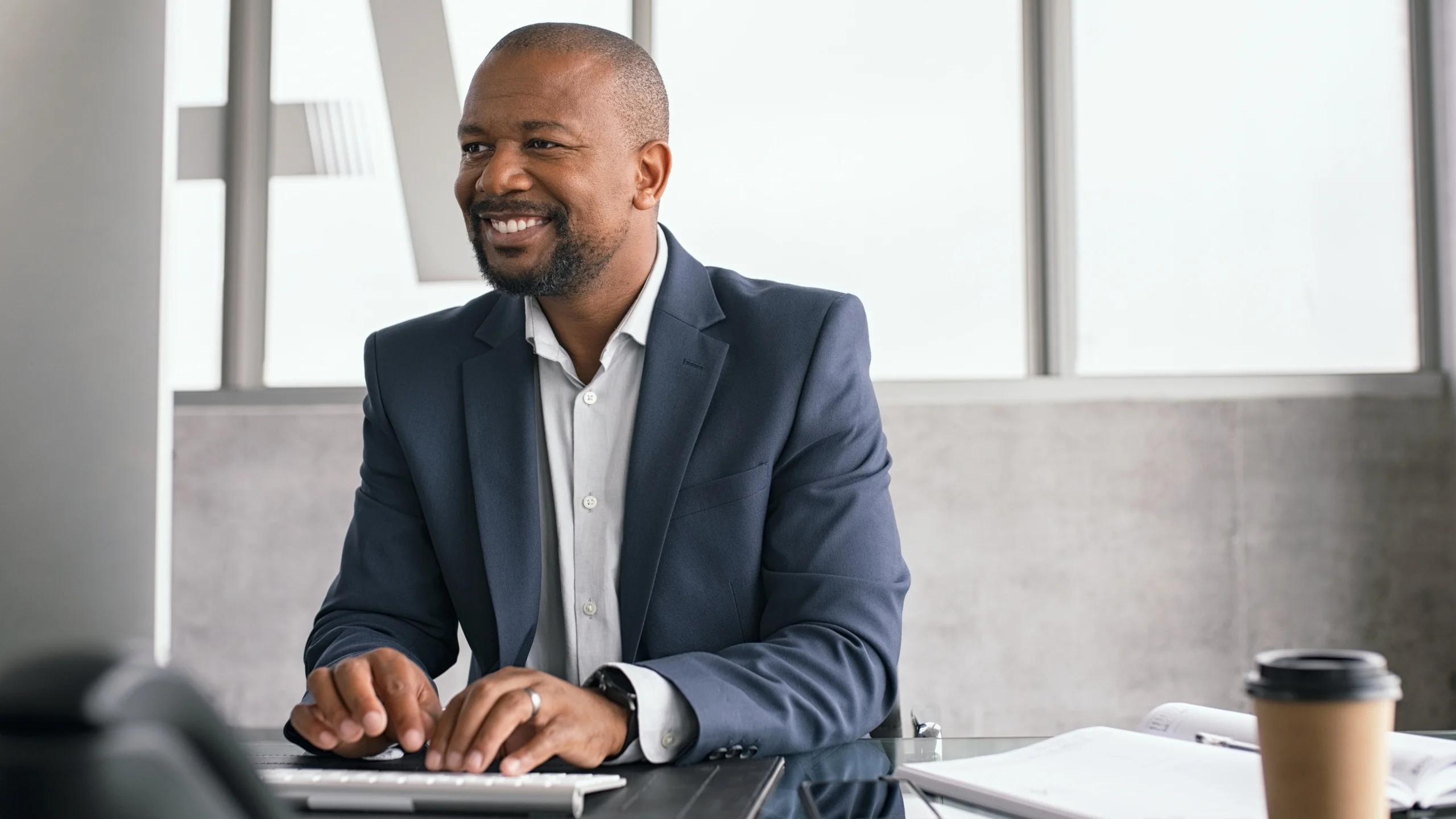 a businessman working on his computer and smiling 