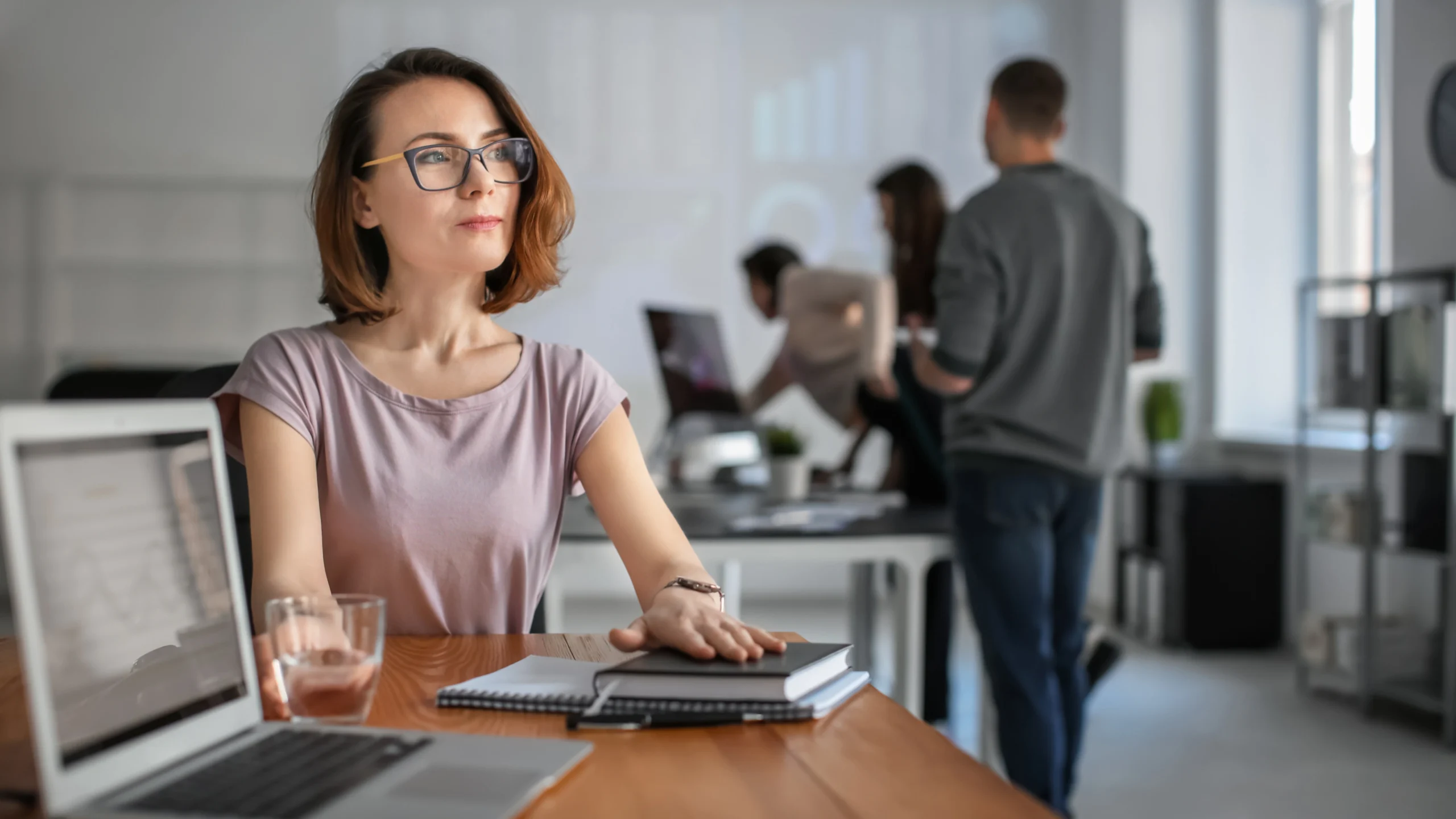 a woman at her place of employment with other workers in the background