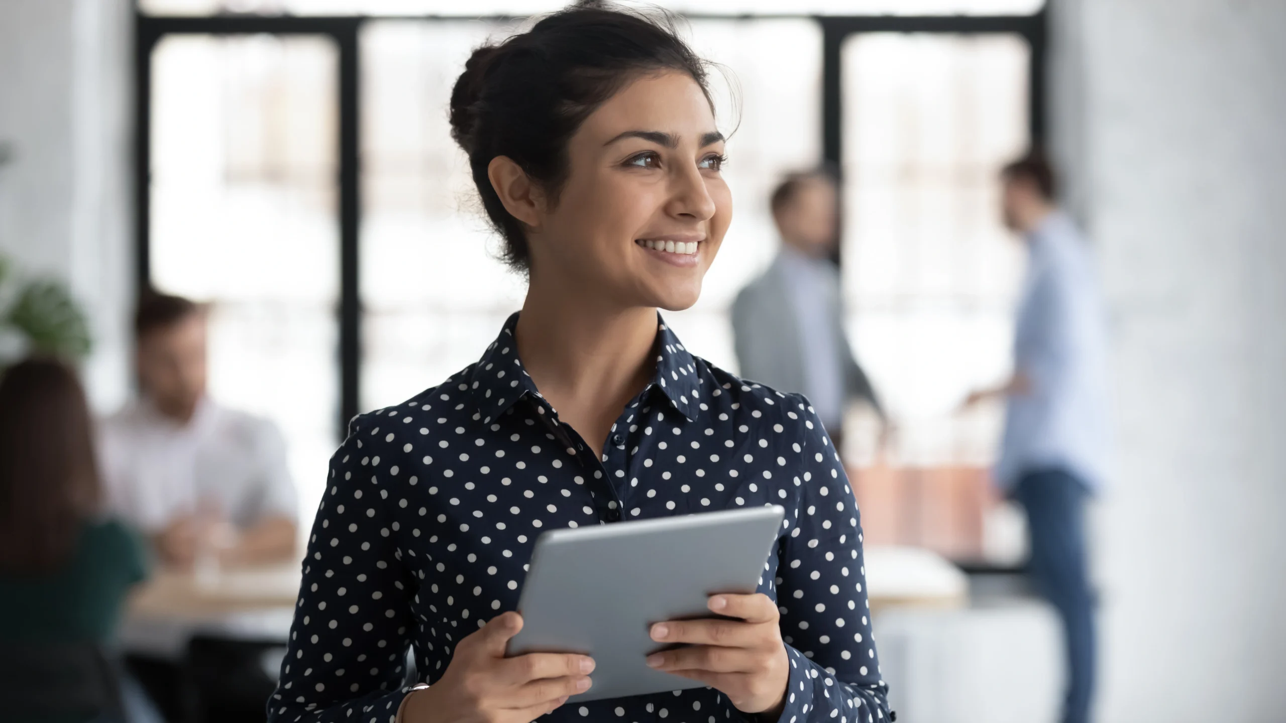 A woman standing in her office and smiling