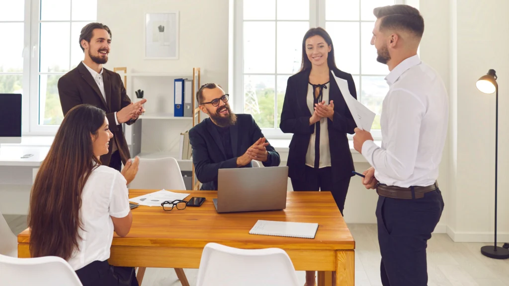 a group of people gathered in the office talking about their work