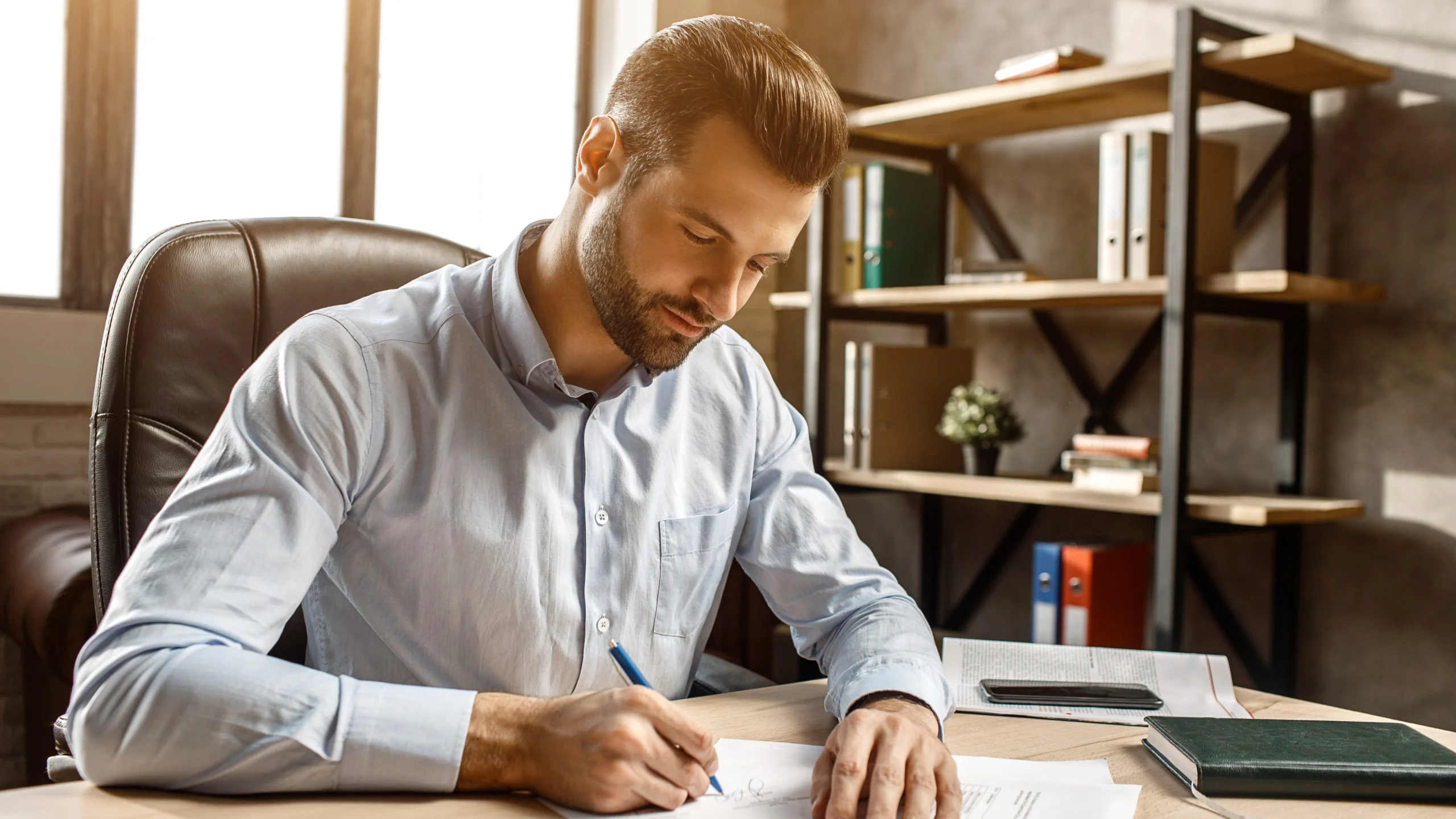 a man writing with a pen on a form