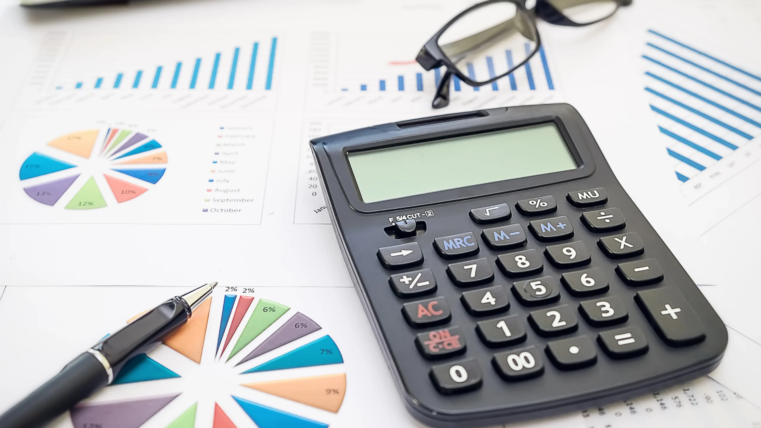 a calculator, pen, and important documents on a table