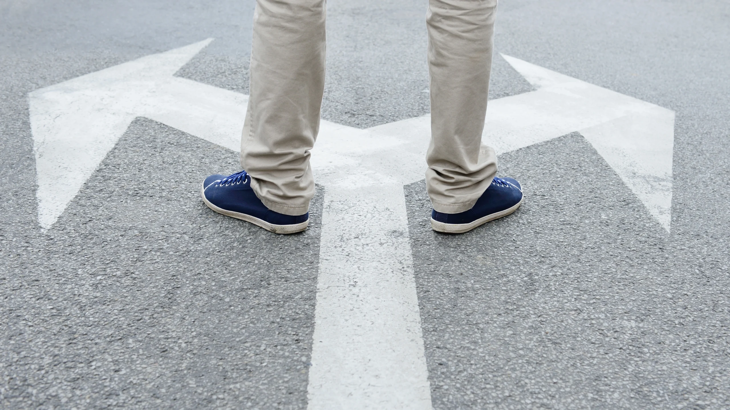 a man having to choose between two different paths to walk on a road