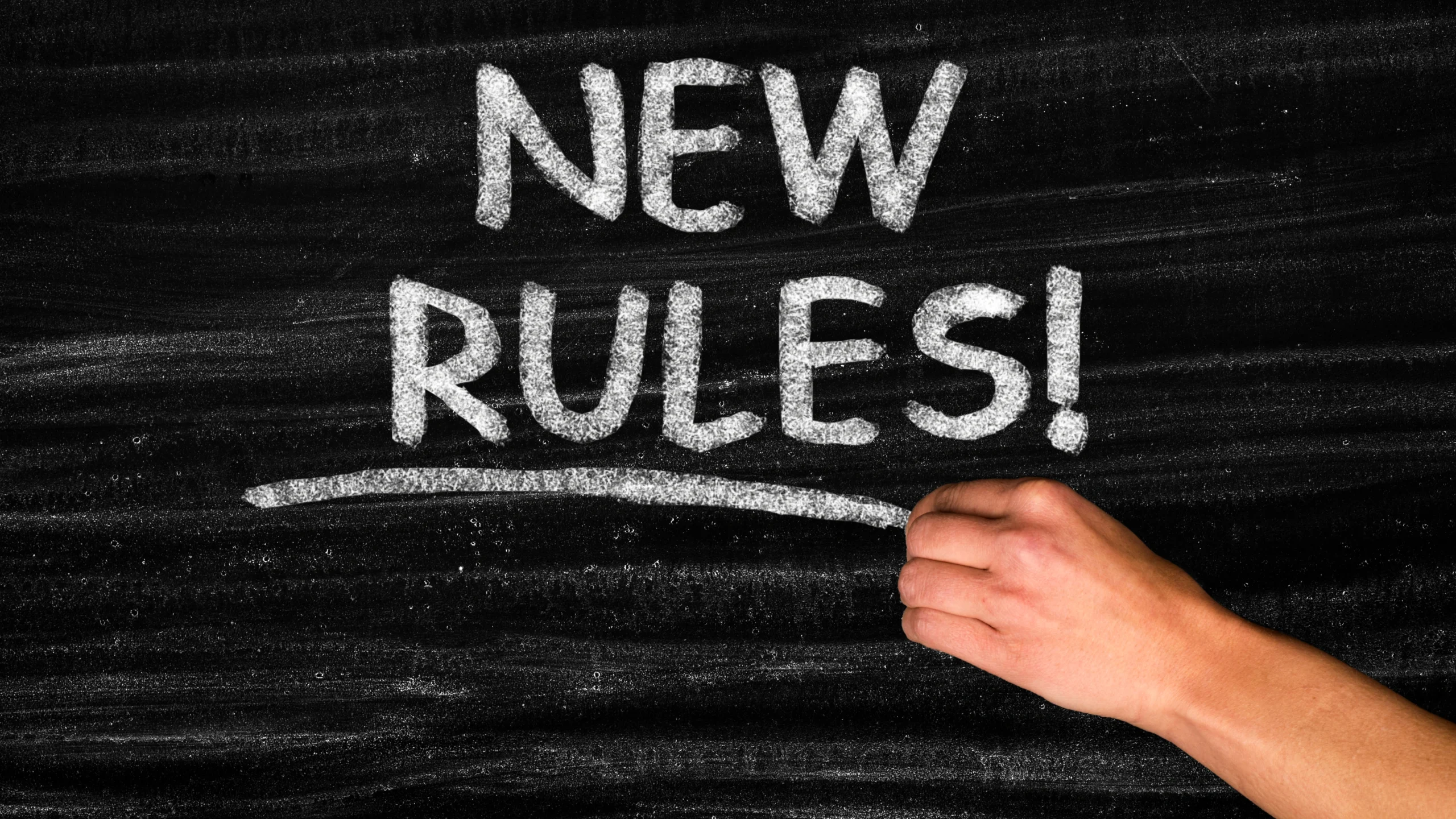 the words new rules written on a black board with white chalk