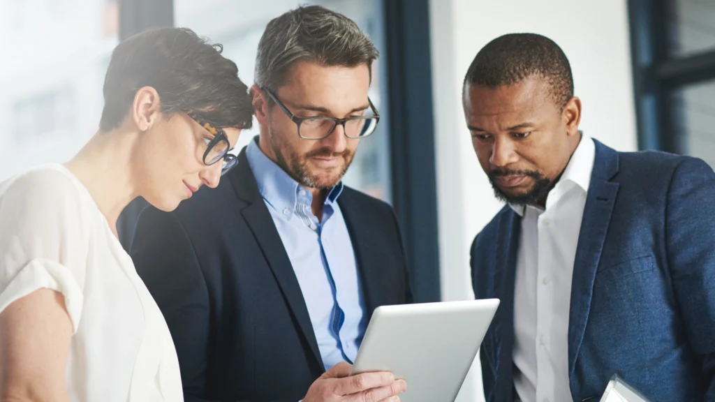 three service providers in their office looking at the same device