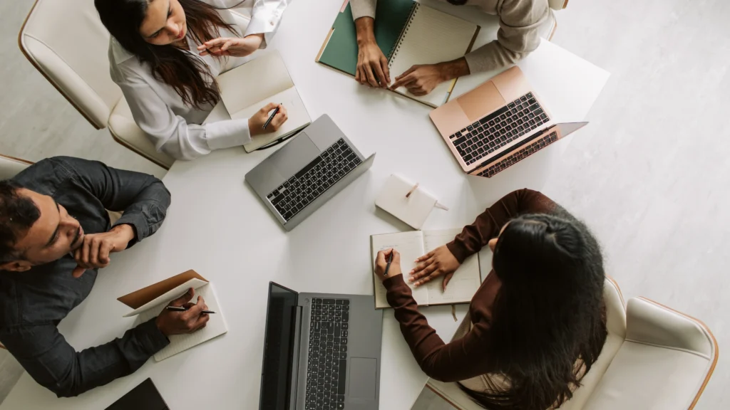 multiple people working together around a desk in their office