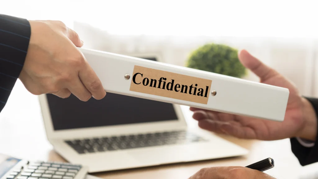 two men passing a folder that says confidential